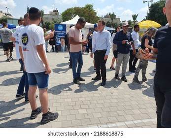 Tel Aviv, Israel - August 10, 2022: Some Men And Women Gather Around Economist Avraham Avi Simhon (Simchon). Boaz Bismuth Tent In The Background Likud Party Primary Election At Menora Mivtachim Arena.