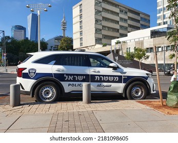 Tel Aviv, Israel - July 17, 2022: Israeli police car parking next to a sidewalk. Background: Tel Aviv Yafo law courts buildings complex. 