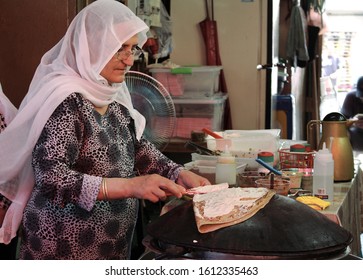 Tel Aviv / Israel - June 24th 2016: A yemenite elderly woman preparing the traditional dish lahoh at carmel market in Tel Aviv