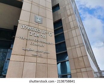 Tel Aviv, Israel - March 24, 2022: Closeup of the sign of Tel Aviv Government Complex in Hebrew, English and Arabic. Above the Menorah, emblem of the State of Israel. Kirya Tower or Hayovel skyscraper