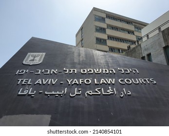TEL AVIV, ISRAEL - March 30, 2022: Tel Aviv - Yafo Law Courts. Sign in Hebrew, English and Arabic. The Emblem of the Menorah on the black triangular wall. Shot from below.