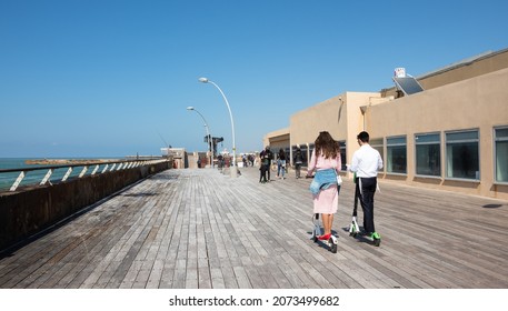 TEL AVIV, ISRAEL - MARCH 6, 2019: Young Jewish couple ride on electric scooters in Tel-Aviv Port which is popular recreational and commercial area for locals and tourists. 