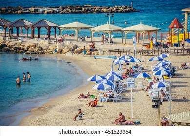 Tel Aviv, Israel - October 18, 2015. People sunbathes on the beach next to Hilton Hotel in Tel Aviv