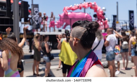 Tel Aviv - June 14th 2019: Pride Parade: Back Portrait Of A Young Woman In The Crowd With An Interesting Haircut. Truck Pulling A Parade Float In Background.