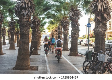 Tel Aviv/Israel-12/10/18: cyclists on the bike lane along the alley with the lines of palm trees on the Sderot Nordau Street in Tel Aviv, Israel