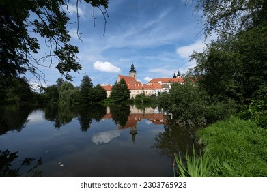Telc city Panorama with dramatic sky. Water reflection of houses and Telc Castle, Czech Republic. UNESCO World Heritage Site.