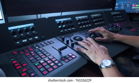 Telecine controller machine and man hand editing or adjusting color on digital video movie or film in the post production stage. 