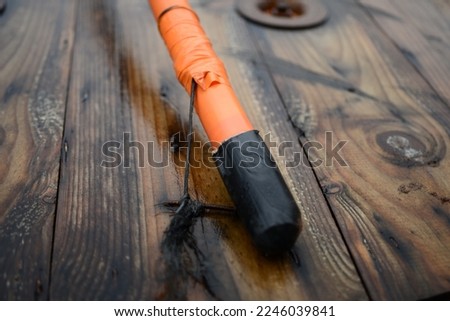 Telecom copper cable type 83220061 local distribution infrastructure Underground coiled orange copper cable plastic black rubber protection head end on a reel attached with a cord to the wooden frame