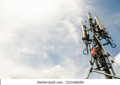 Telecommunication Engineer Working On High Tower,Risk Work Of High Work,Technician Working With Safety Equipment On Tower,Sky Background.Technician Take Picture While Working On Tower.