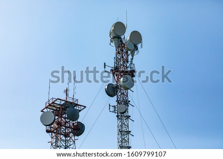 Telecommunication and mobile network infrastructure with two cell site towers side by side, housing antennas and Remote Radio Head, RRH, for greater coverage