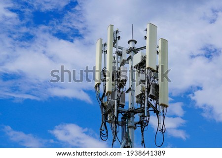 Telecommunication tower of 4G and 5G cellular. Macro Base Station. 5G radio network telecommunication equipment with radio modules and smart antennas mounted on a metal on cloulds sky background.