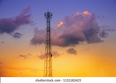Telecommunication tower with antenna and technician working on sunset sky
