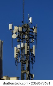 Telecommunication tower with copy space.Digital wireless 4G and 5G connection system.Development of communication systems in urban areas.and pole with electric line in Sao Paulo - Shutterstock ID 2368673681