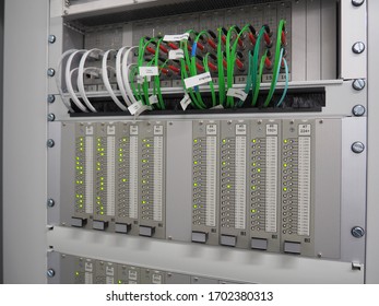 Telecommunications Equipment. Green Optic Fiber Cables And Green Lighting Indicators Rack Mounted Inside The Steel Cabinet.