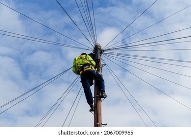 Telecommunications, telecom engineer at work on the top of a telegraph pole