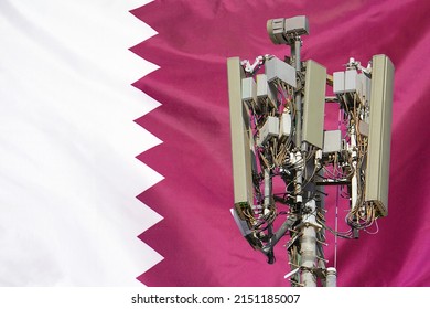 Telecommunications Tower With A 5G Cellular Network Antenna Agains Flag Of Qatar. Telecommunication Tower Of 5G Cellular Communication. 5G Technology Usage On Telecommunications Towers In Qatar