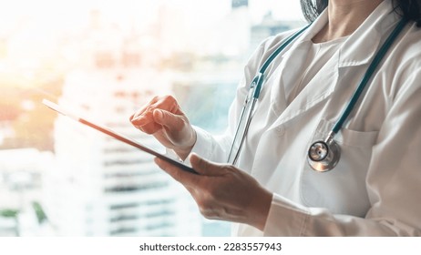 Telehealth and telemedicine by medical doctor or physician consulting patient’s health online using mobile digital tablet in hospital for professional emergency tele-healthcare assistance service
