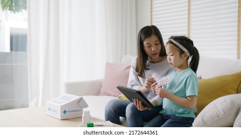 Telehealth telemedicine care mobile app exam visit service asia people. Worry mom and sick kid girl ask doctor in video call talk VoIP clinic self cure with cold flu Rx box pill at sofa home isolate. - Shutterstock ID 2172644361