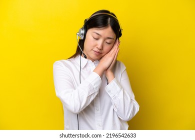 Telemarketer Chinese Woman Working With A Headset Isolated On Yellow Background Making Sleep Gesture In Dorable Expression