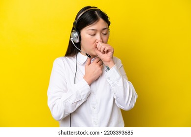 Telemarketer Chinese Woman Working With A Headset Isolated On Yellow Background Is Suffering With Cough And Feeling Bad