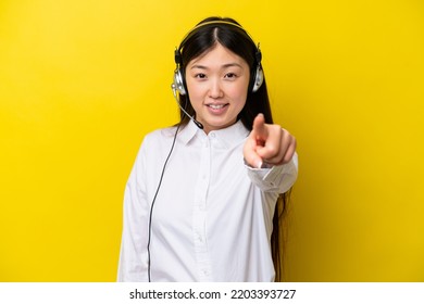 Telemarketer Chinese Woman Working With A Headset Isolated On Yellow Background Points Finger At You With A Confident Expression