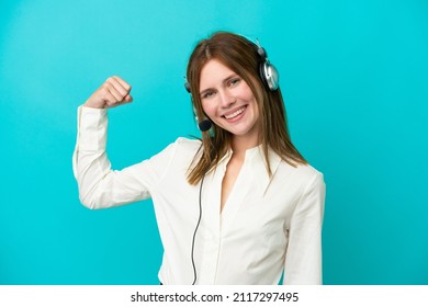 Telemarketer English Woman Working With A Headset Isolated On Blue Background Doing Strong Gesture