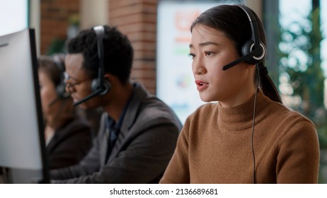 Telemarketing operator using headset to guide clients, helping with sales assistance and support at call center. Female employee talking to people on helpline, working at customer service.