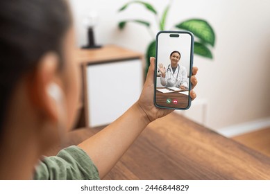 Telemedicine in action with a female doctor greeting a patient through a smartphone video call at home. - Powered by Shutterstock