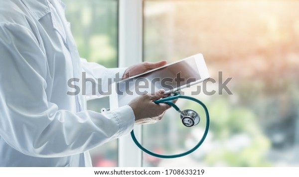 Telemedicine by medical doctor or physician\
consulting patient’s health telehealth online using mobile tablet\
in clinic or hospital for professional digital emergency healthcare\
assistance service