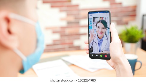 Telemedicine Concept - Asian Female Doctor Explain About Disease To The Male Patient By Video Chat With Smartphone And Show Ok Gesture