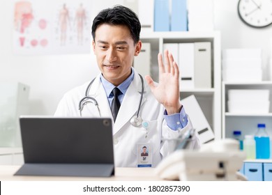 Telemedicine Concept - Asian Male Doctor Is Talking To Patient On Digital Tablet Online