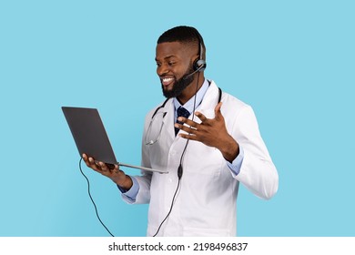 Telemedicine Concept. Black Male Doctor With Laptop And Headset Making Online Consultation, Smiling African American Physician Talking To Patient Via Video Call On Computer, Copy Space