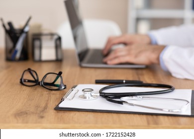 Telemedicine Concept. Close Up Side View Of Clinician Using Computer, Typing On Keyboard, Focus On Medical Equipment