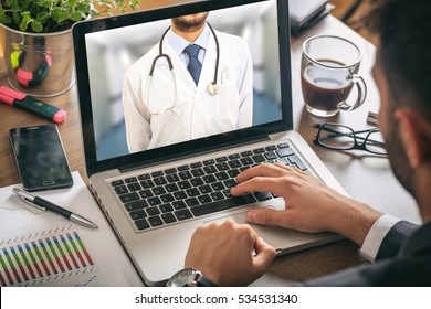 Telemedicine Concept. Doctor Gp On A Computer Screen In An Office Environment. 