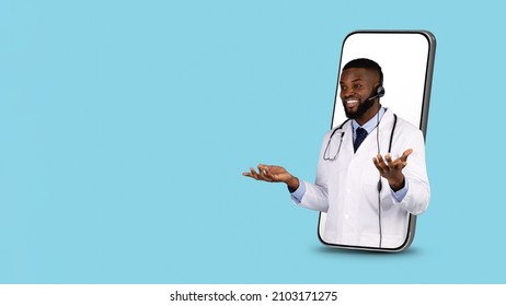 Telemedicine Concept. Doctor In Headset Peeking Out Of Big Smartphone Screen Over Blue Background, African American Male Therapist In Uniform Consulting Patient Online, Collage With Copy Space - Powered by Shutterstock