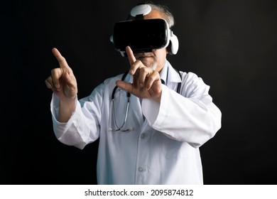 Telemedicine concept, old Asian doctor in lab uniform wearing VR glasses and operating medical task standing  on black background. - Powered by Shutterstock