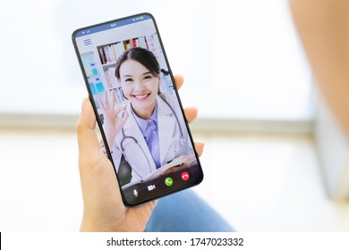 Telemedicine concept - patiient has video chat with asian female doctor