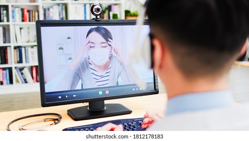 Telemedicine Concept -  Rear View Of Asian Male Doctor Listen Female Patient Talking About Disease By Video Chat