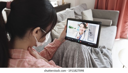 Telemedicine concept - rear view of asian woman has video chat with female doctor by digital tablet