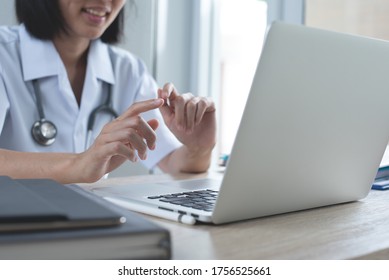 Telemedicine, Teleconference, Telehealth, Medical Online, Ehealth Concept. Asian Female Doctor Video Calling, Using Zoom Meeting Online App Via Laptop Computer In Medical Office, Close Up