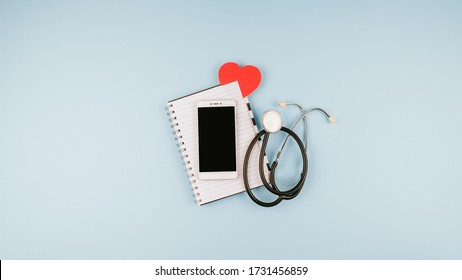 Telemedicine Or Telehealth Virtual Visit, Video Visit, Remote Doctor Video Chat Consultation Concept With Laptop, Smartphone, Notepad And Stethoscope On Blue Background.