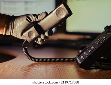 Telephone Fraud And Night Theft By A Criminal Hacker On A Phone Conversation. A Man Hand In A Black Glove With A Phone On A Dark Background