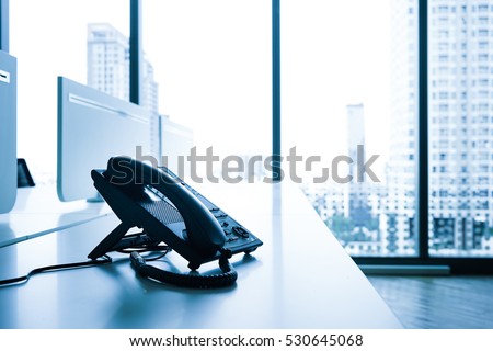 Telephone on desk with big window city view.Modern office concept.