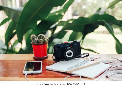 Telephone paper book note camera cactus pencil on table
