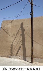 The Telephone Pole Shadow On The Mud Wall.