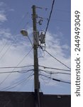 telephone pole with wires against cloudy blue sky
