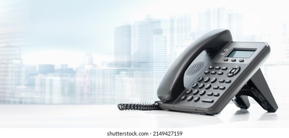 telephone with VOIP on white table on blurred city background. customer service support, call center concept. telephone devices at office desk. Modern VoIP or IP phone. - Shutterstock ID 2149427159