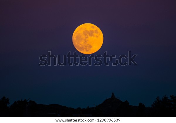 Telephoto image of red wolf moon, full moon over\
Victoria, BC, Canada