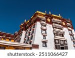 A telephoto shot emphasizes the intricate details of the White Palace of Potala Palace in Lhasa, Tibet, showcasing the architectural grandeur and traditional Tibetan design of this historic landmark.