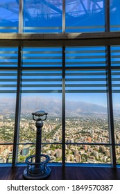 Telescope at the glass windows of the observatory of the Sky Costanera, with no people and Andes mountains view, Gran Torre Santiago, South America’s tallest building, Santiago, Chile 12.21.17